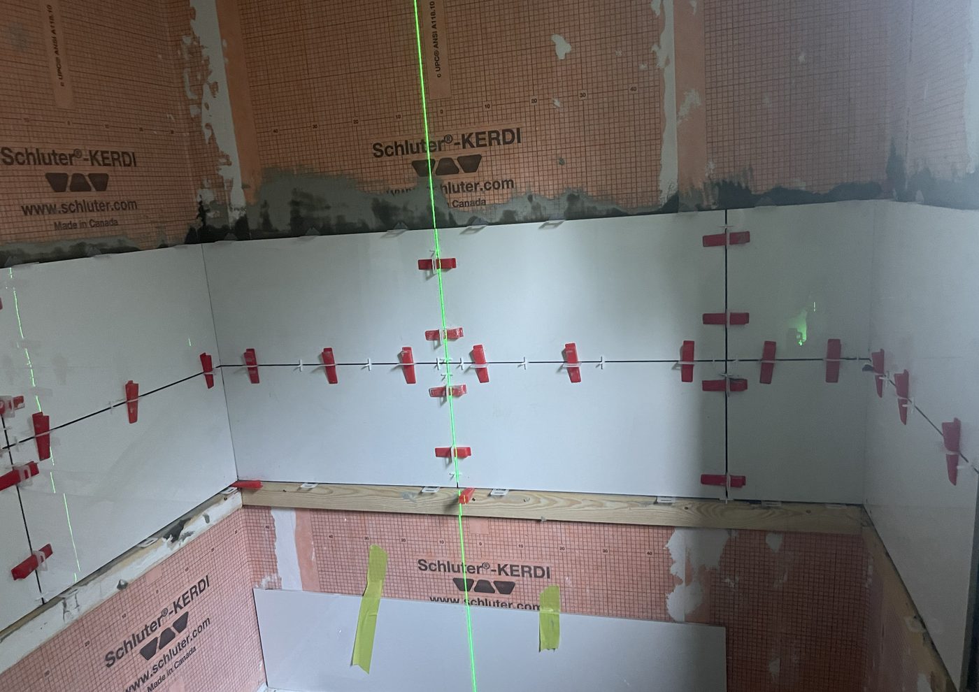 Laser-levelled wall tile installation over waterproofed shower walls by Luxevita Construction